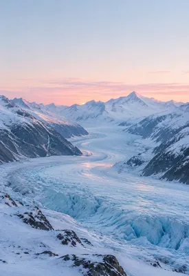 iPhone Duo glacier dawn wallpaper for the cover screen, A glacier valley at first light, pale blue ice, snow-covered ridges, and a thin rose horizon. 1398x2034 px