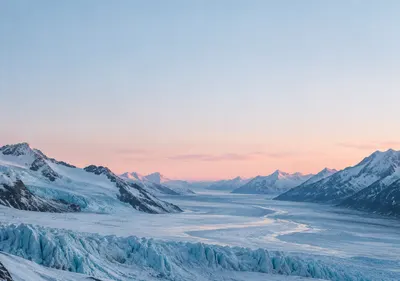 iPhone Duo glacier dawn wallpaper for the inner display, A glacier valley at first light, pale blue ice, snow-covered ridges, and a thin rose horizon. 2670x1878 px