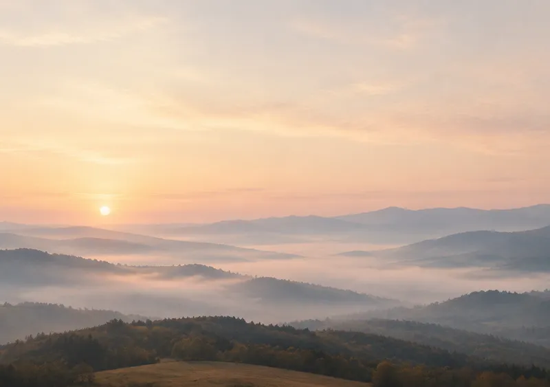 iPhone Duo pale dawn wallpaper for the inner display, a wide soft cream and blush dawn over a misty valley, 2670x1878 px